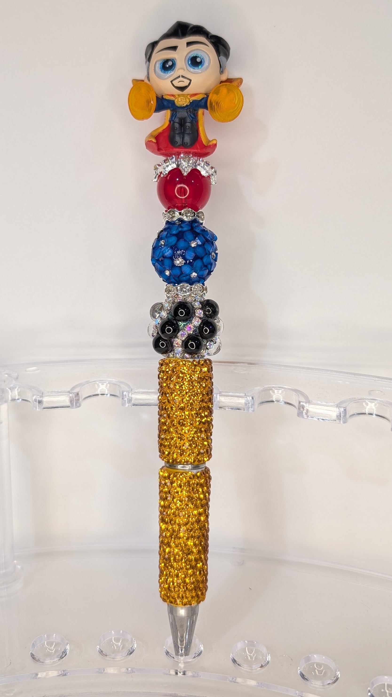 Decorative pen with a Doctor Strange doorable top on a white surface